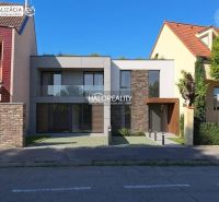 Dvoupatrový dům s velkými okny mezi domy ve městě Trnava, Pozemky - bydlení.
