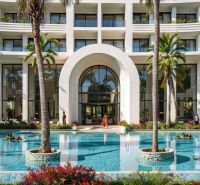 Bazén u luxusního hotelu s palmami v Paje.