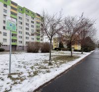 Zasněžená ulice Novozámocká ve Zvolenu s komerčními pozemky a bytovými domy.