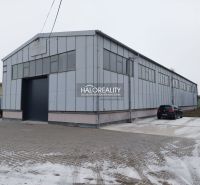 Sklady a haly v KE - Džungle s velkou průmyslovou budovou a asfaltovou plochou.