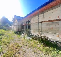 Výstavba rodinného domu v Badíně, okres Banská Bystrica, se zeleným okolím a lešením.