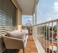 Balkon 3-pokojového bytu v Bratislavě - Ružinově s venkovním posezením a dřevěným dekorem.