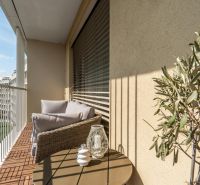 Balkon v 3-pokojovém bytě s pohodlným sezením, výhledem a dekoracemi.