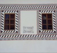 Historická budova na ulici Dolná v Banské Bystrici s okny a fasádními ornamenty.
