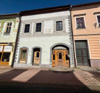 Ulice Dolná v Banské Bystrici zobrazuje historické budovy s obchody a barem.