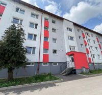 Bytový dům na ulici Za Nožiarňou, Slovenská Ľupča, s výraznými červenými panely.