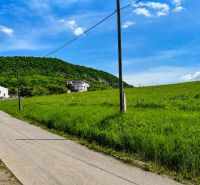 Kopcovitá krajina u Fintic s pozemky na bydlení a venkovem v pozadí.