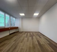 Kanceláře s velkými okny a podlahou s dřevěným dekorem.
