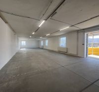 Prostorný interiér skladů a hal s betonovou podlahou a množstvím denního světla.