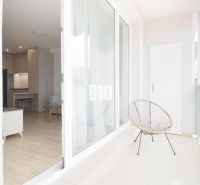Balkon s průhledným zábradlím a výhledem do interiéru 2-pokojového bytu.