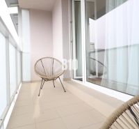 Balkon s posezením v 2-pokojovém bytě s dlážděnou podlahou.