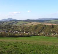 Pohled na zemědělské a lesní pozemky v Bogliarce s kopcovitým horizontem a vesnicí.