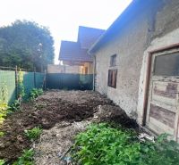 Starší rodinný dům v Brehoch, Nová Baňa, okres Žarnovica, s hliněným dvorem a vegetací.