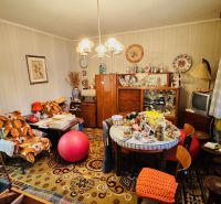 Pokoj plný vintage nábytku a dekorací ve 3-pokojovém bytě s podlahou s dřevěným dekorem.