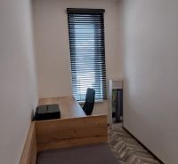 Pracovní kout s psacím stolem a podlahou s dřevěným dekorem ve 4-pokojovém bytě.
