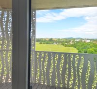 Balkon s panoramatickým výhledem a podlahou s dřevěným dekorem v 2-pokojovém bytě.