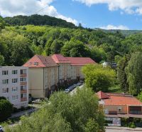 Výhled na okolí 2-pokojového bytu na Křižovatce v Banské Štiavnici, obklopený zelení.