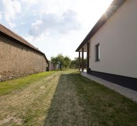 Pohled na dvůr rodinného domu v Zemplínské Široké s travnatým porostem.
