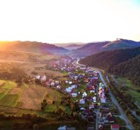 Krajina v okolí Nové Bystrice se zemědělskými a lesními pozemky při západu slunce.