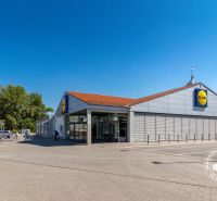 Prodejna Lidl v Bratislavě - Petržalce, Vígľašská, s parkovištěm a zákazníky.