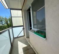 Balkon s dlažbou a zábradlím v 2-pokojovém bytě.