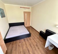 Ložnice se světlým interiérem, postelí a podlahou s dřevěným dekorem ve 4pokojovém bytě.
