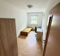 Jedna z zařízených místností ve 4pokojovém bytě s podlahou s dřevěným dekorem.
