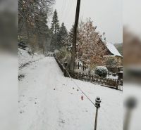Zasněžená ulice v Horních Otrokovicích s rodinným domem a oplocením.