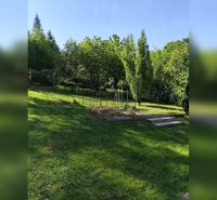 Zahrada u rodinného domu v Horních Otrokovicích, zelený trávník a ovocné stromy.
