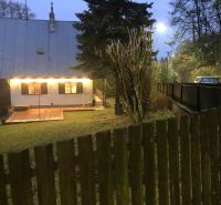 Rodinný dům v Horních Otrokovicích na ulici Horní Otrokovice s osvětlenou terasou a bránou.
