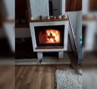 V rodinném domě se nachází krb na podlaze s dřevěným dekorem.