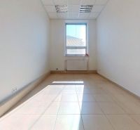 Světlá kancelář s dlaždicovou podlahou a velkým oknem propouštějícím světlo.