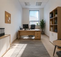 Světlá kancelář s dřevěným nábytkem, koberec, rostliny a motivační nápis na stěně.