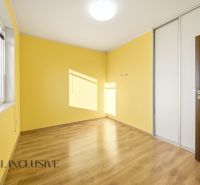 Žlutý pokoj ve 3-pokojovém bytě s podlahou s dřevěným dekorem a vestavěnou skříní.