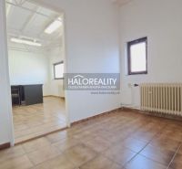 Kanceláře s dlaždicovou podlahou, radiátorem a přirozeným světlem.
