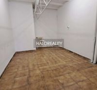 Interiér kanceláře s bílými stěnami a hnědou dlažbou.
