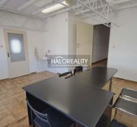 Kanceláře s dlaždicovou podlahou a stolem s černými židlemi v prostoru.