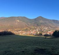 Krajina v obci Ľubietová obklopená horami, vesnická architektura a klidné prostředí.