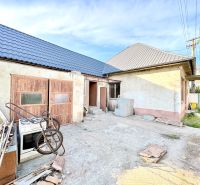 Rodinný dům v Šoporni se dvěma střechami a neudržovaným dvorem.