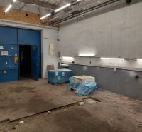Sklady a haly s modrými dveřmi, osvětlením a materiály na podlaze s dřevěným dekorem.