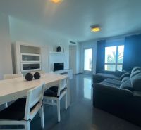 Jídelní stůl se židlemi a pohovkou, Rekreační apartmán, podlaha s dřevěným dekorem.