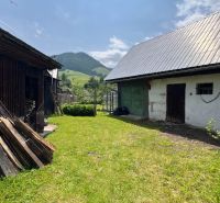 Rodinný dům v Liptovské Lúžné se zahradou, dřevěným přístřeškem a horskou scenérií.