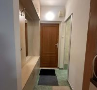 Vstupní chodba v rekreačním apartmánu se zabudovanými skříněmi a věšáky.