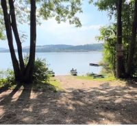 Jezero obklopené stromy u chaty v Liptovské Sielnici, loďky na vodě.