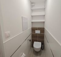 Útulná koupelna s podlahou s dřevěným dekorem v 1-pokojovém bytě.