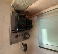 Stará elektrická rozvodná skříň v garáži, se starými jističemi a zásuvkami.