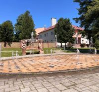 Fontána a lavička s vyřezávanými postavami v obci Polomka.