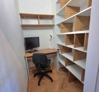 Pracovní kout s podlahou s dřevěným dekorem a policemi v 2pokojovém bytě.