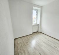 Pokoj v 1-pokojovém bytě s podlahou s dřevěným dekorem a světlou stěnou.