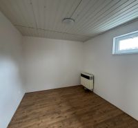 Pokoj s podlahou s dřevěným dekorem a bílými stěnami v 2-pokojovém bytě.